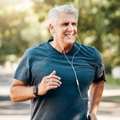 Older man running with headphones and fitness device