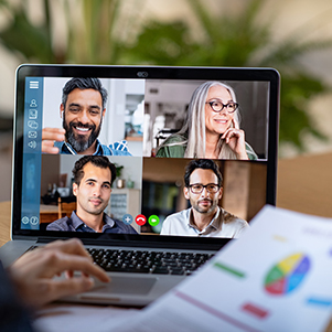 Laptop with a zoom conference call and business charts to represent the increased privacy and fraud threats for working form home