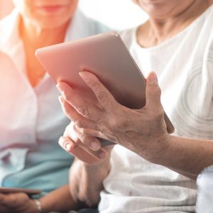 Elderly women holding technology to represent senior citizen privacy protection